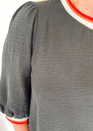 black loose fitting top with 3/4 length sleeve - round neck and cuff have colored banding