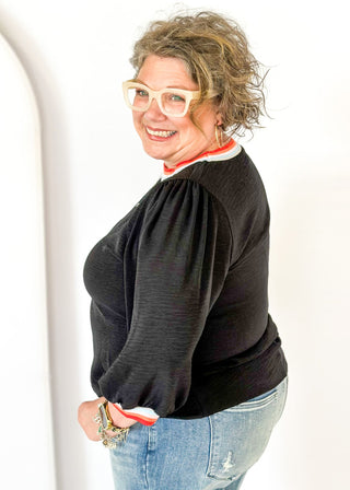 black loose fitting top with 3/4 length sleeve - round neck and cuff have colored banding