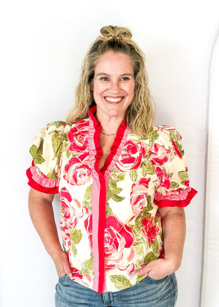 pink and green floral short sleeve top with pink ruffle detail around neckline and cuffs - button snap closure down the front
