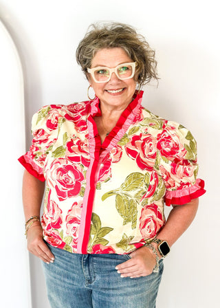 pink and green floral short sleeve top with pink ruffle detail around neckline and cuffs - button snap closure down the front