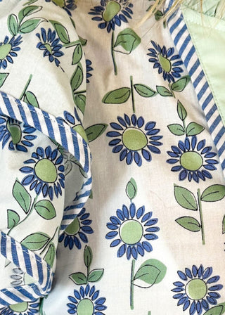 Mint and blue flowers with green stems on a cream background double ruffle short sleeve top - v-neck - mint band around ruffle collar and v-neck - blue and white piping detail around double ruffle short sleeves and v-neck