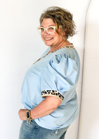 light blue puff short sleeve top w/leopard and tan trim around v-neck and cuff