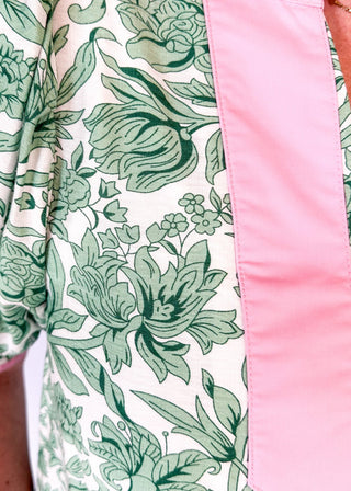 green floral on white elbow length sleeve top - light pink banding detail around collar and v-neck - 2 light pink stripes around cuff