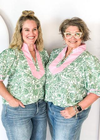 green floral on white elbow length sleeve top - light pink banding detail around collar and v-neck - 2 light pink stripes around cuff