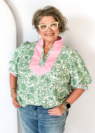 green floral on white elbow length sleeve top - light pink banding detail around collar and v-neck - 2 light pink stripes around cuff