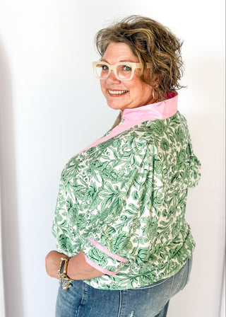 green floral on white elbow length sleeve top - light pink banding detail around collar and v-neck - 2 light pink stripes around cuff