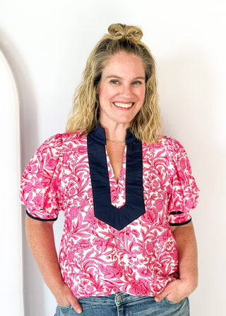 bright pink floral on white elbow length sleeve top - navy banding detail around collar and v-neck - 2 navy stripes around cuff