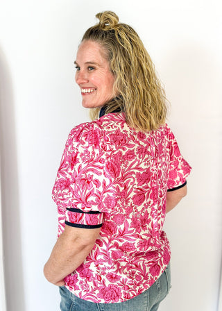 bright pink floral on white elbow length sleeve top - navy banding detail around collar and v-neck - 2 navy stripes around cuff