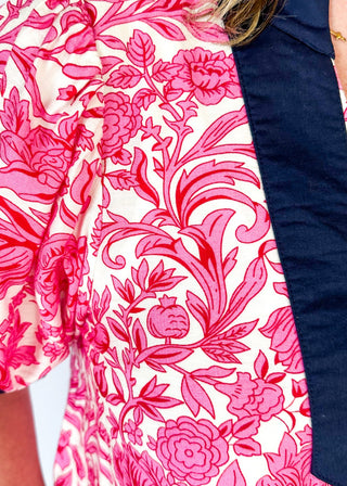 bright pink floral on white elbow length sleeve top - navy banding detail around collar and v-neck - 2 navy stripes around cuff