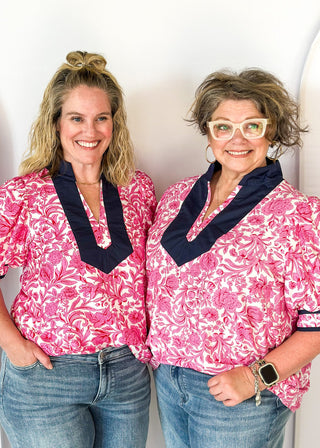 bright pink floral on white elbow length sleeve top - navy banding detail around collar and v-neck - 2 navy stripes around cuff