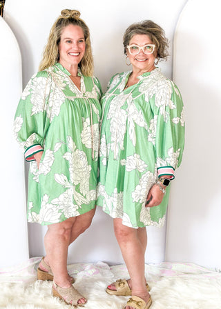 Mint green Dress with large cream flowers.  Tie front collar with 3/4 oversized balloon sleeve- contrasting color stripe on the sleeve, lined with pockets. 