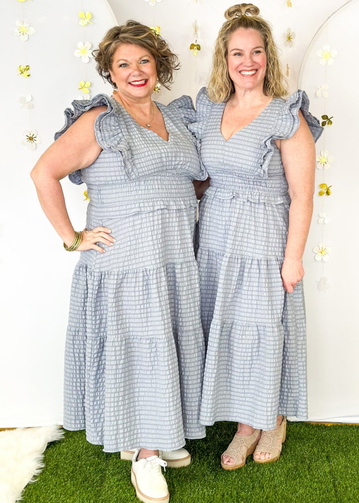 Flutter sleeve, V-neck tiered dress-ruffle detail at waist. Solid color in a blue-gray with seersucker like texture. 