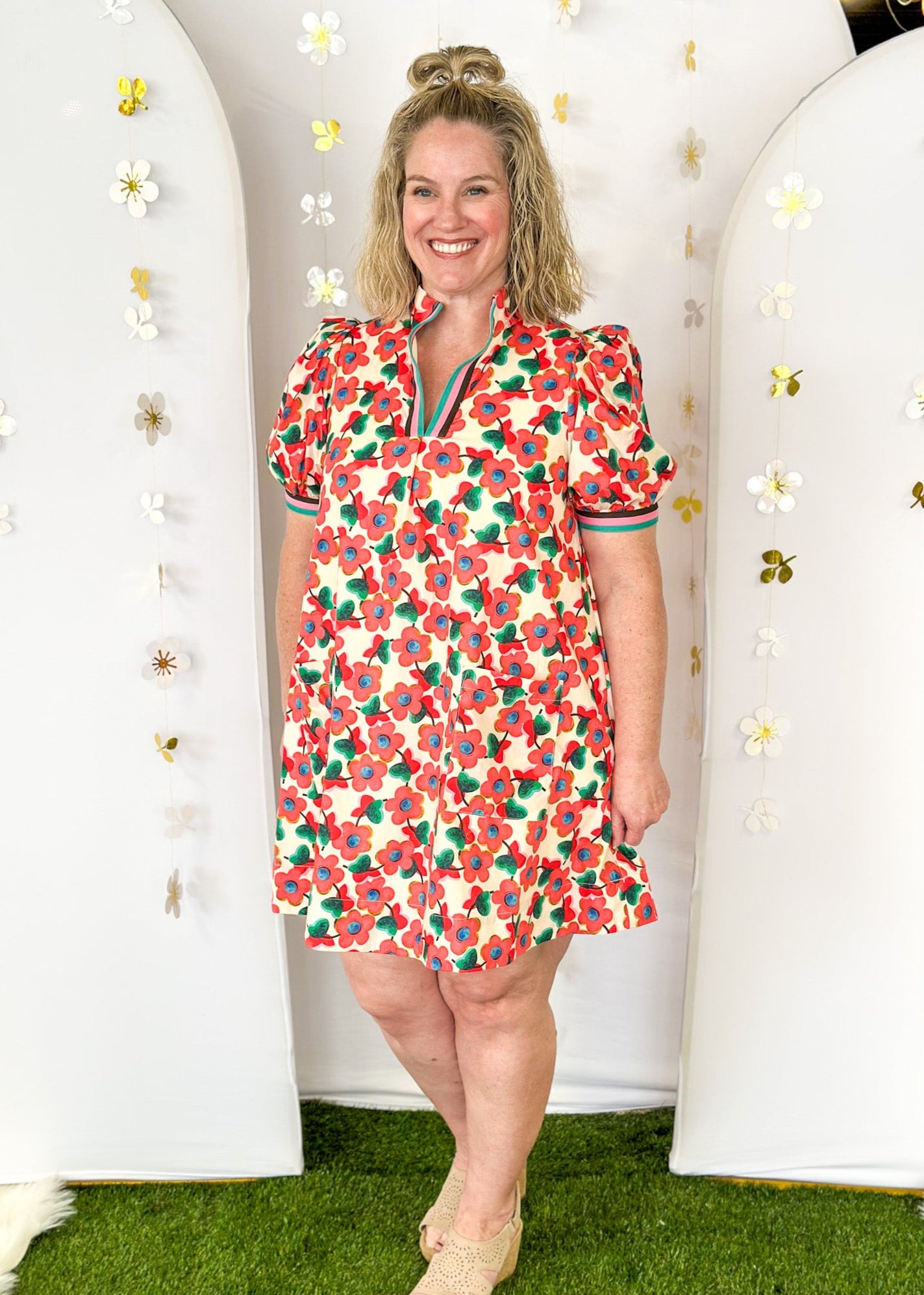 Cream base v-neck dress with light red floral pattern.  Contrasting stripe sleeve and collar. Lined with pockets.