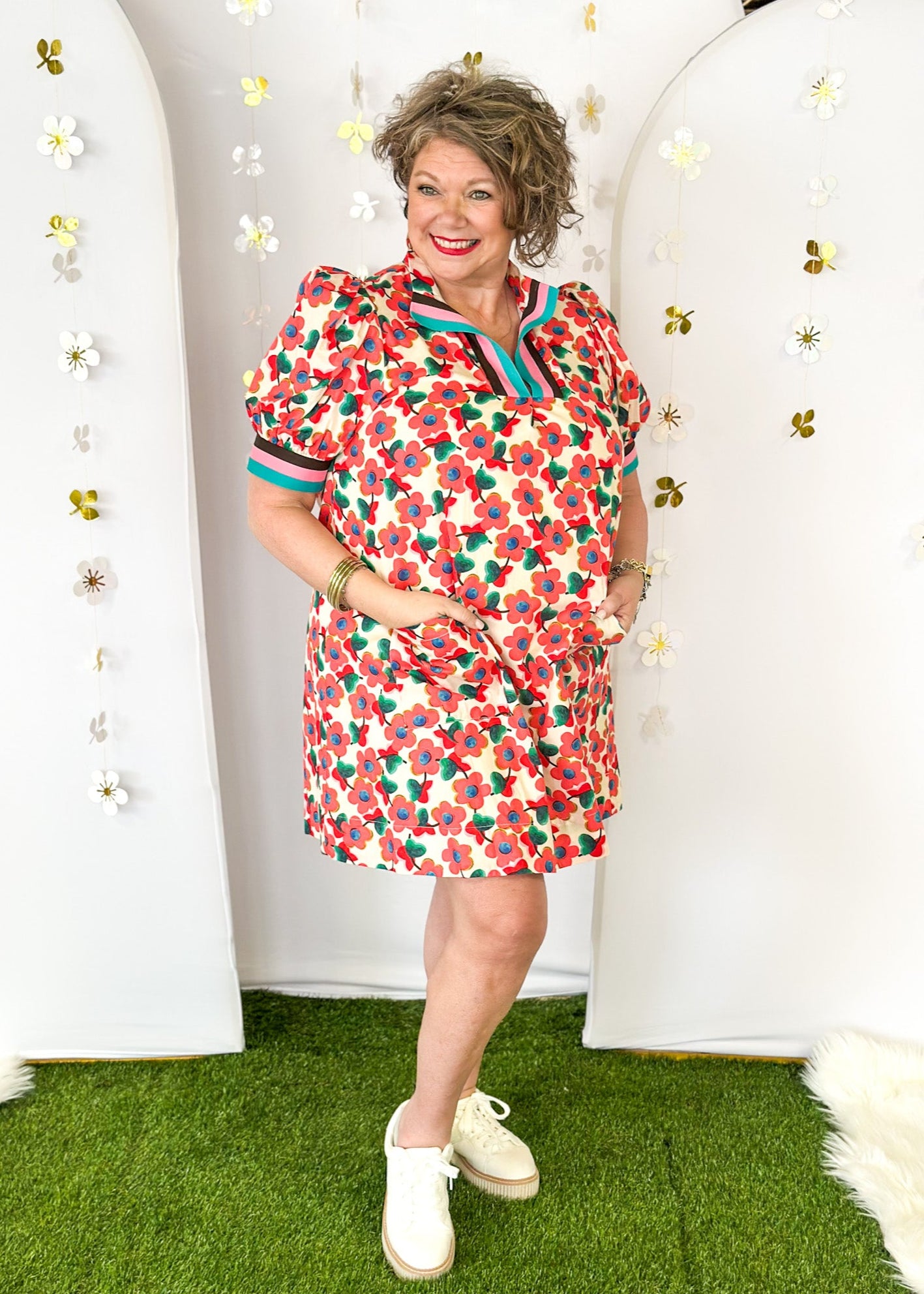 Cream base v-neck dress with light red floral pattern.  Contrasting stripe sleeve and collar. Lined with pockets.