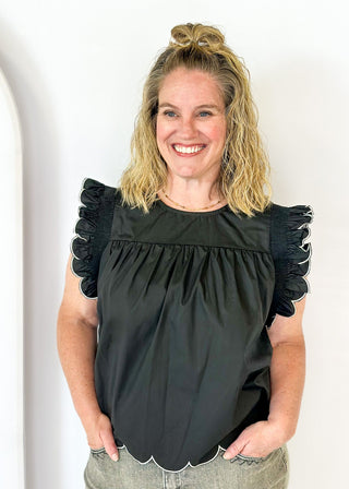  black ruffle sleeve top with scalloped trim in white around the sleeve and bottom - round neck - button closure on the back