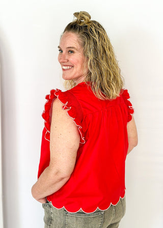 red ruffle sleeve top with scalloped trim in white around the sleeve and bottom - round neck - button closure on the back