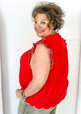 red ruffle sleeve top with scalloped trim in white around the sleeve and bottom - round neck - button closure on the back