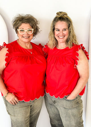 red ruffle sleeve top with scalloped trim in white around the sleeve and bottom - round neck - button closure on the back