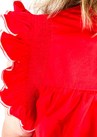 red ruffle sleeve top with scalloped trim in white around the sleeve and bottom - round neck - button closure on the back