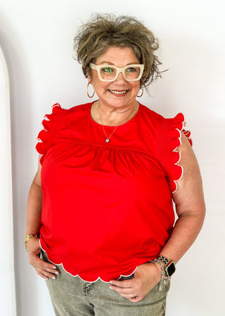 red ruffle sleeve top with scalloped trim in white around the sleeve and bottom - round neck - button closure on the back