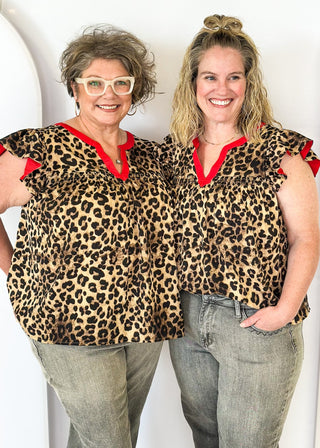 leopard print top with v-neck and short ruffle sleeve - red banding detail around v-neck and neckline - red detail under ruffle sleeve - flowy fit
