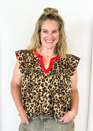 leopard print top with v-neck and short ruffle sleeve - red banding detail around v-neck and neckline - red detail under ruffle sleeve - flowy fit