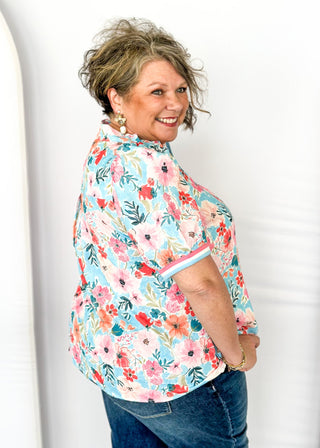 bright floral top with striped detail around arm band and v-neck - aqua, blues, pinks and white - short puff sleeve with little shoulder pads