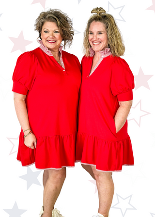 red sporty short sleeve dress with a bottom tier ruffle - button v-neck with red and white stripes around ruffle collar, bottom trim and line across the back.